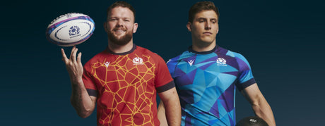 Two rugby players in Scotland jerseys stand side by side; one wears a red jersey holding a ball, and the other in a blue jersey holds a rugby helmet.