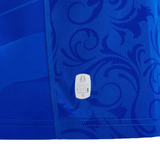 Close-up of a blue Italy 24/25 Replica Home Jersey by Macron, featuring a swirling pattern and an eco-friendly label near the seam, crafted with Eco Fightex Fabric inspired by Italian art.