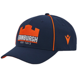 The Edinburgh Baseball Cap 24/25 by Macron is a navy blue cap featuring orange trim and a castle design. It prominently displays "EDINBURGH" and "EST. 1872" below, along with a side logo, capturing classic style ideal for the 24/25 season.