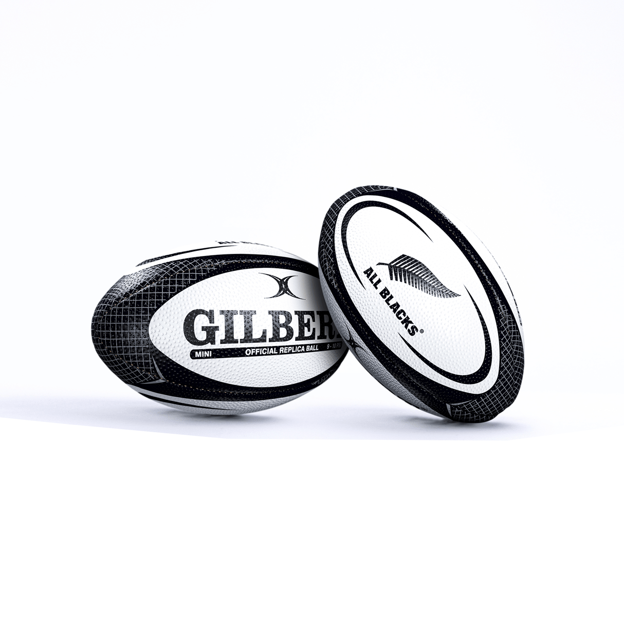 Two All Blacks Mini Balls by Gilbert, one upright and one on its side, against a white background.