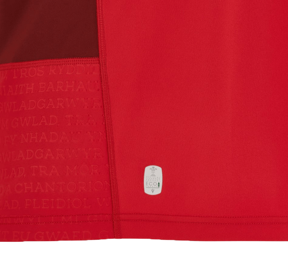 A close up of a Macron Wales Rugby Union 23/24 Home Jersey with a button on it.