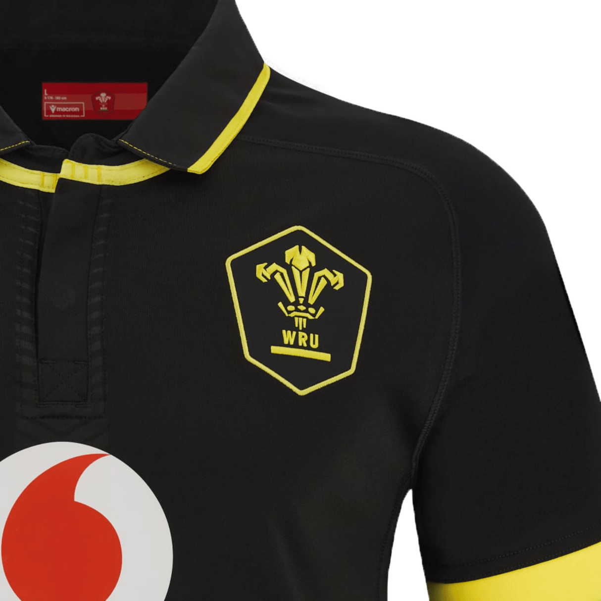 A black and yellow rugby shirt with the Wales Rugby Away Jersey 23/24 by Macron logo on it.