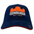 Introducing the Edinburgh Cap 23/24 by Macron: This navy blue cap showcases an orange castle logo on the front, with "EDINBURGH" and "EST. 1872" printed in white underneath. Crafted from lightweight polyester, it features an adjustable buckle closure for a perfect fit.