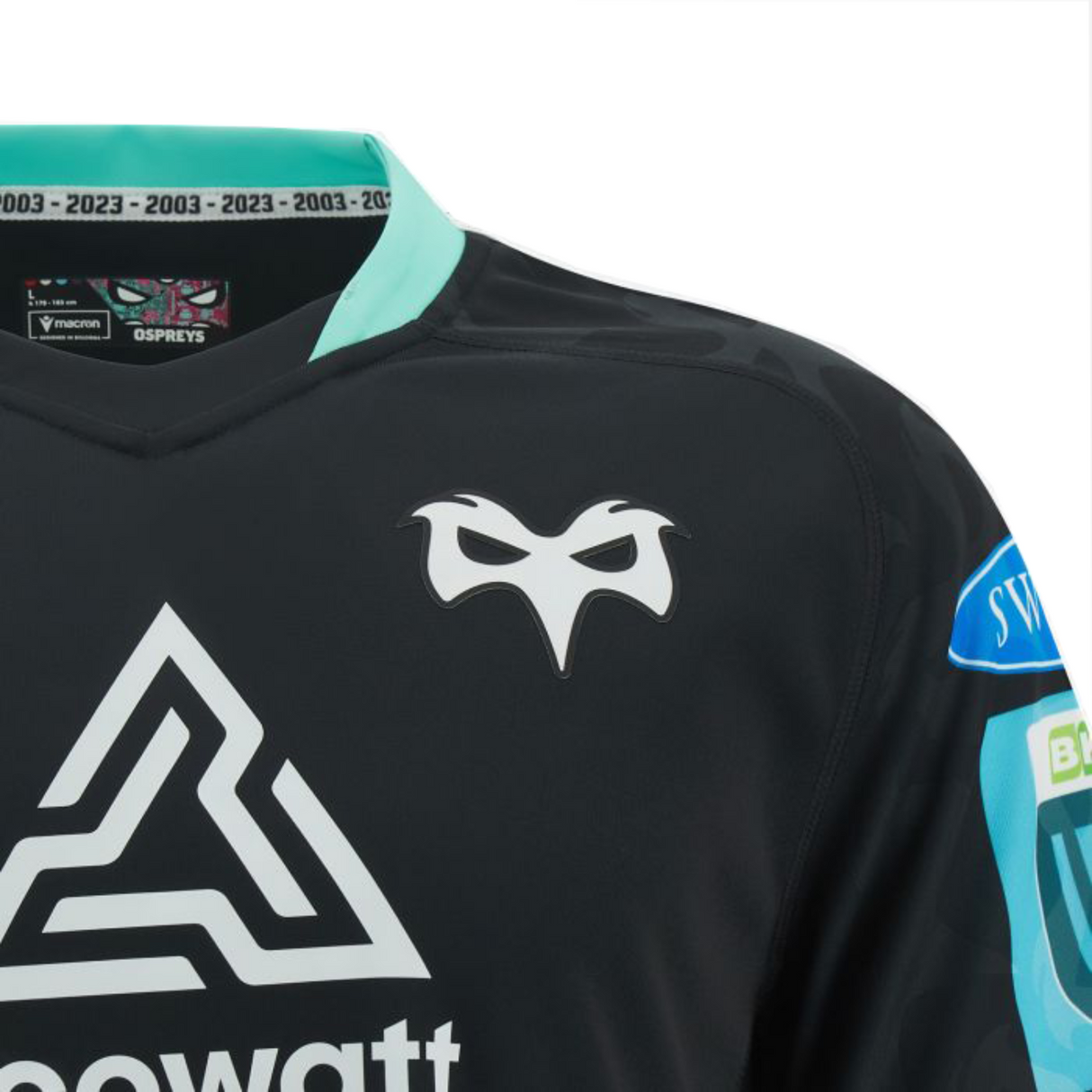 Close-up of the Ospreys Home Jersey 23/24 by Macron, a sleek black sports jersey with light blue and white accents. It showcases the Ospreys logo, sponsor branding, and commemorative text along the collar. Crafted from high-tech fabric for an athletic fit by the Macron brand.