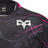 Close-up of a black Ospreys Rugby 24/25 Poly Cotton T-shirt by Macron, showcasing a stylized white mask logo and abstract pink and gray patterns, designed by the official supplier for Ospreys Rugby.