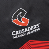 Close-up of the Crusaders rugby team logo with "Mā pango mā whero" text on black fabric, highlighting the Black and Red design that defines their iconic Crusaders Super Rugby Replica Away Jersey 25/26 by Classic Sportswear.