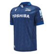 The Sale Shark Rugby 24/25 Home Jersey by Macron features a blue design with geometric patterns. It proudly displays the "Toshiba" logo on the front, a prominent Sale Shark Rugby emblem on the chest, and sponsorship patches adorning the sleeves, making it perfect for dedicated fans.