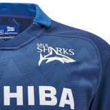 Here's a closer look at the Sale Shark Rugby 24/25 Home Jersey by Macron. This navy blue rugby jersey prominently features the Sale Sharks logo alongside an eye-catching shark design, complemented by the white Toshiba sponsor text. Ideal for fans of Sale Shark Rugby, this jersey is a must-have.