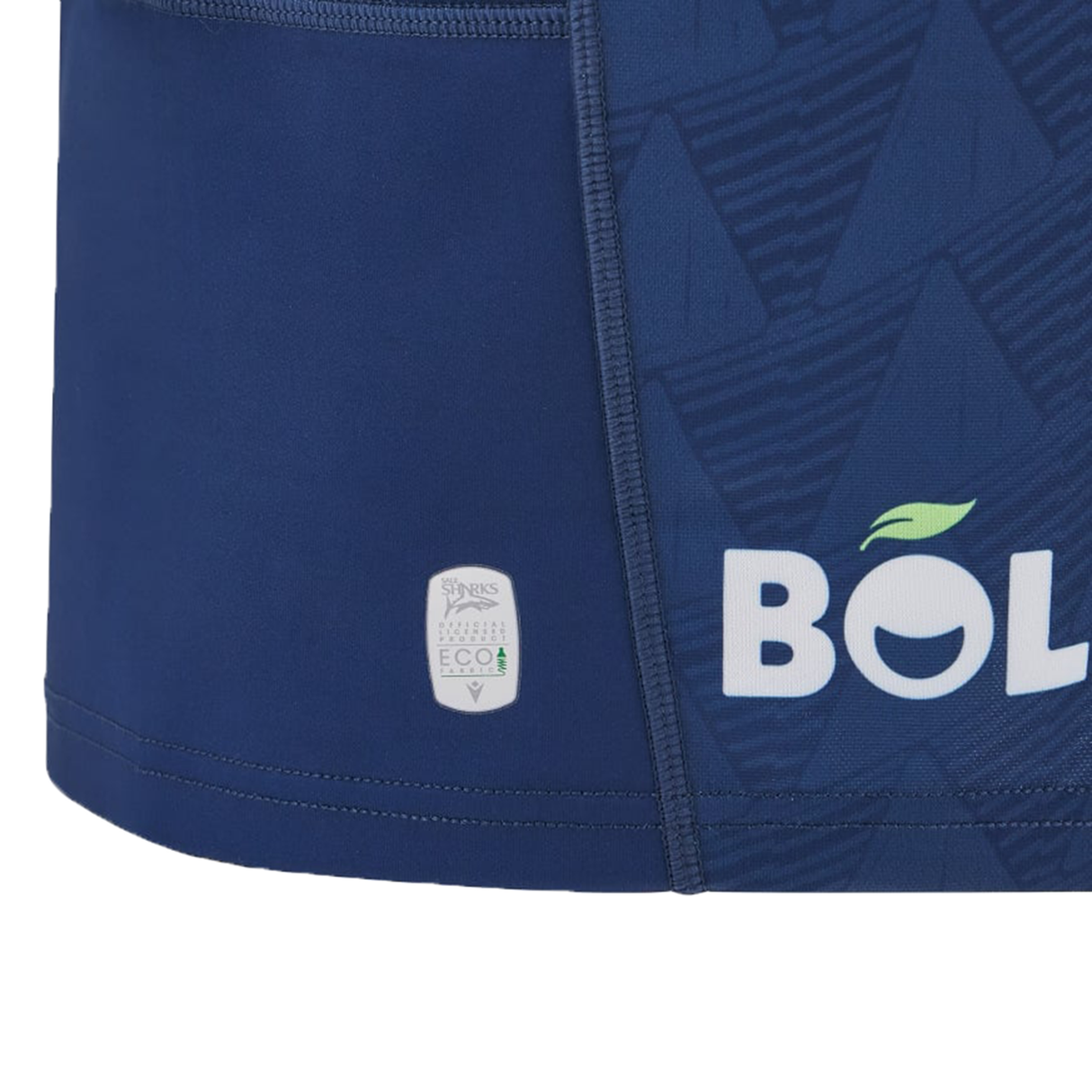 Close-up of a blue garment adorned with a stylized mountain logo and the word "BOLE," complete with a leaf detail, reminiscent of the Sale Shark Rugby 24/25 Home Jersey by Macron. Below, there's an eco-friendly badge that aligns with the sustainability ethos found in this Macron product.