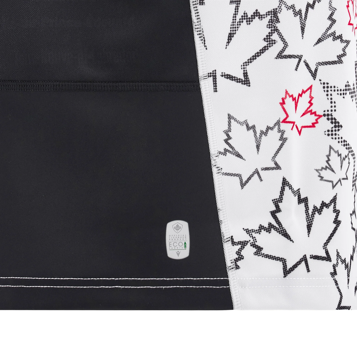 A detailed view of fabric showcasing a black and white maple leaf pattern, evocative of the Canada 24/25 Away Jersey by Macron. Several leaves are highlighted with red outlines for a vibrant touch, alongside a small eco label. This design is a subtle homage to styles in Macron's upcoming 24/25 collection.