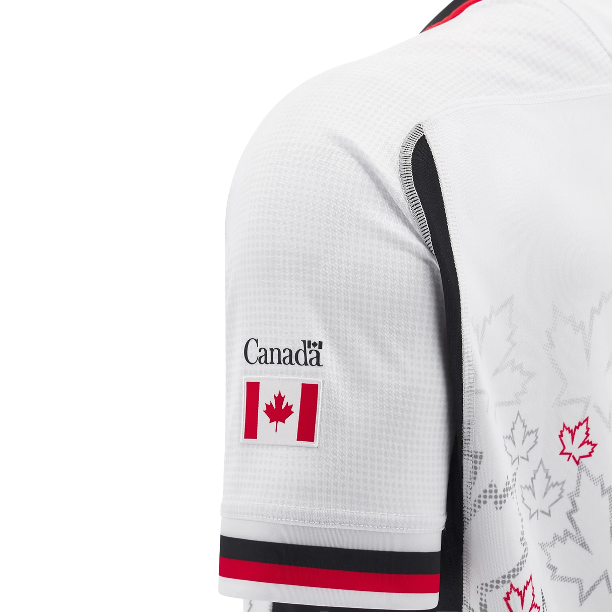 A side view of the Macron Canada 24/25 Away Jersey, a white athletic jersey adorned with black and red details, showcasing a small Canadian flag and "Canada" text on the sleeve.