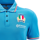 Explore the Italy 24/25 Travel Polo by Macron, a stylish blue shirt highlighting the distinctive Italian rugby emblem and sponsorship label on the chest. Ideal for supporters, this Athleisure Polo from Macron is an essential addition to your collection.