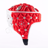 The Gilbert Air Headguard by Gilbert is a red and white padded sports helmet that boasts a lightweight design with multiple circular ventilation holes and a secure strap. Its advanced closed-cell foam padding ensures maximum protection and comfort.