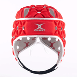 A red and white Gilbert Air Headguard by Gilbert, offering multiple ventilation holes and shock absorption padding for enhanced safety.