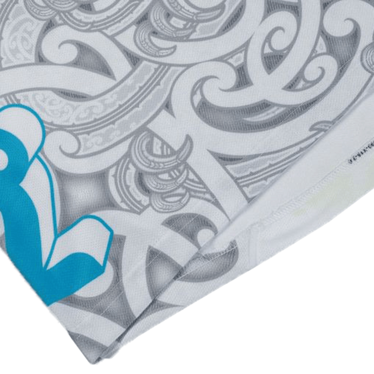 A close-up of a fabric with intricate gray and white swirling patterns and a blue design element on the left side, partially folded, reminiscent of the Gallagher Chiefs Super Rugby Away Jersey 24 by Classic Sportswear.