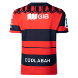 Rear view of a red and navy Crusaders Super Rugby Heritage Jersey by Classic Sportswear with the word "coolabah" on the lower back, featuring sponsor logos and a geometric pattern at the shoulders.