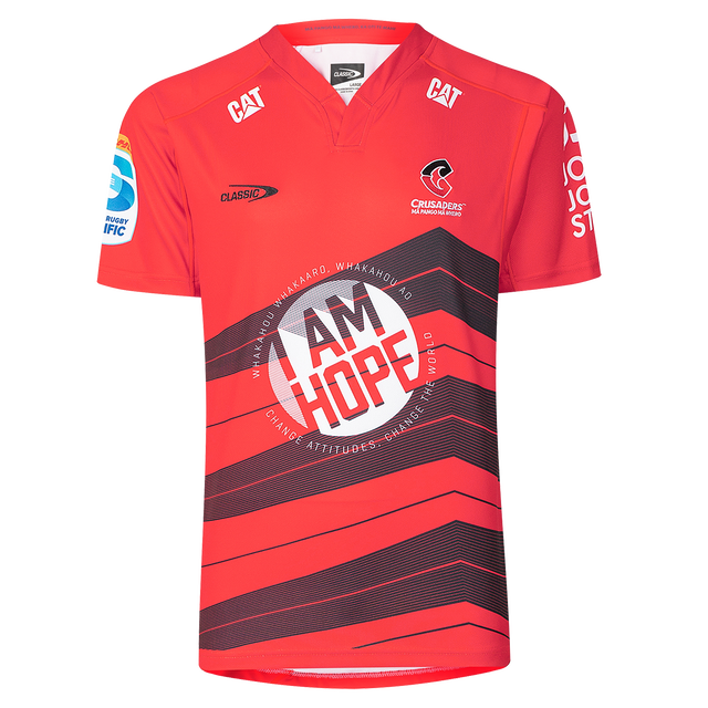 The Crusaders Super Rugby Replica Home Jersey 25/26 by Classic Sportswear features sponsor logos, the "Classic" logo, and the "Crusaders" team logo. It showcases "I AM HOPE" on the front, making it essential for any Super Rugby enthusiast.