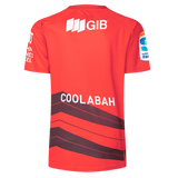 The Crusaders Super Rugby Replica Home Jersey 25/26 by Classic Sportswear is a red sports jersey with "COOLABAH" on the back, black diagonal stripes, and GIB plus other logos on sleeves and upper back. It's perfect for showcasing your Super Rugby pride.