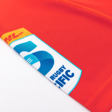 Close-up of the Crusaders Super Rugby Replica Home Jersey 25/26 by Classic Sportswear, a red jersey with the DHL sponsor logo and Super Rugby Pacific logo on the sleeve.