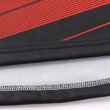 A close-up of black fabric featuring red diagonal stripes and visible stitching evokes a classic sportswear design. This pattern resembles the iconic style found in the Crusaders Super Rugby Replica Away Jersey 25 by Classic Sportswear, encapsulating athletic elegance.