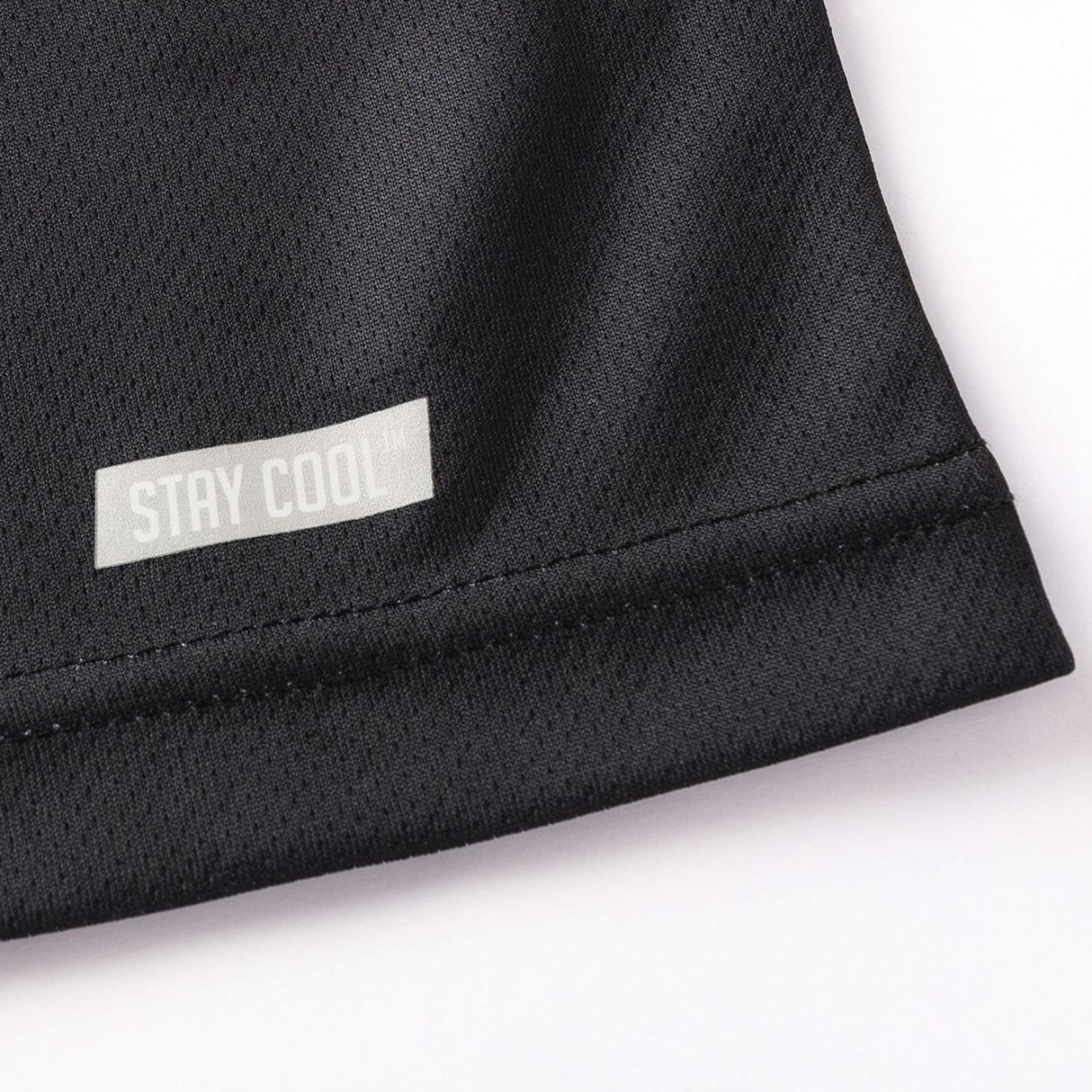 Close-up of a black moisture-wicking fabric from the Crusaders Super Rugby Team Polo 25/26 by Classic Sportswear, showcasing a "STAY COOL" tag in light gray text.