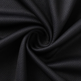 A close-up of black fabric with a swirling pattern highlights its texture and drape, reminiscent of the refined Crusaders Super Rugby Team Polo 25/26 by Classic Sportswear, showcasing premium moisture-wicking qualities.
.