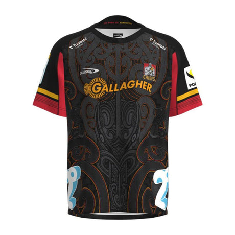 The Gallagher Chiefs Super Rugby Home Jersey 24 by Classic Sportswear showcases an intricate black, red, and orange design. It features a relaxed fit with anti-microbial wickable fabric. The short-sleeved jersey includes multiple logos: "Gallagher" prominently at the center, along with other sponsors on the sleeves and chest.