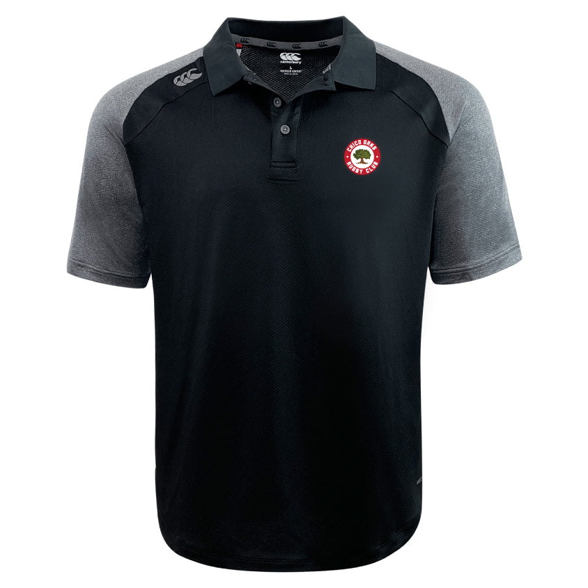 The Chico Oaks Elite Polo by EMB Canterbury is a black and gray short-sleeve shirt made with Vapodri fabrics for lightness and durability, featuring a small red and white emblem on the left chest.