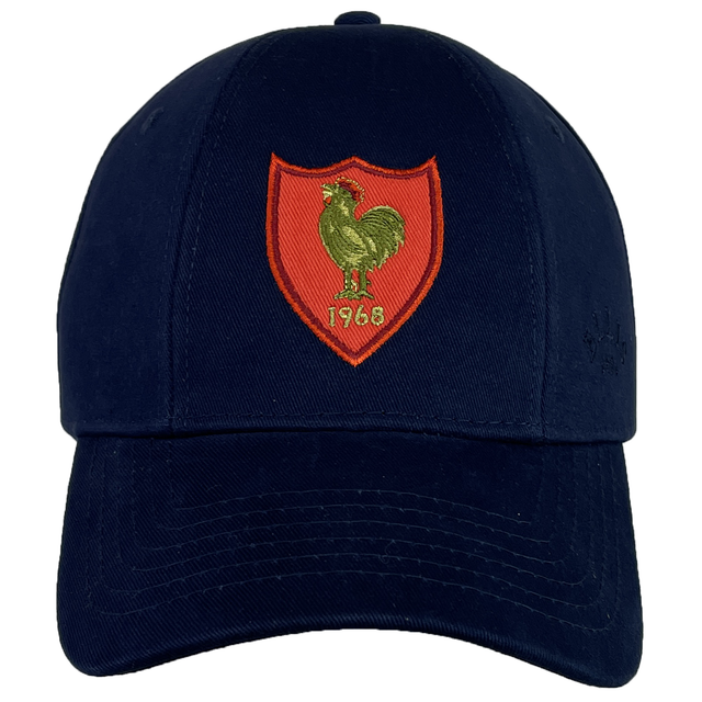 The France Rugby 1968 Grand Slam Cap by Ellis Rugby is designed in navy and includes an embroidered red shield with a gold rooster and the year "1963," reflecting the essence of French rugby heritage and alluding to their Grand Slam victory in 1968.