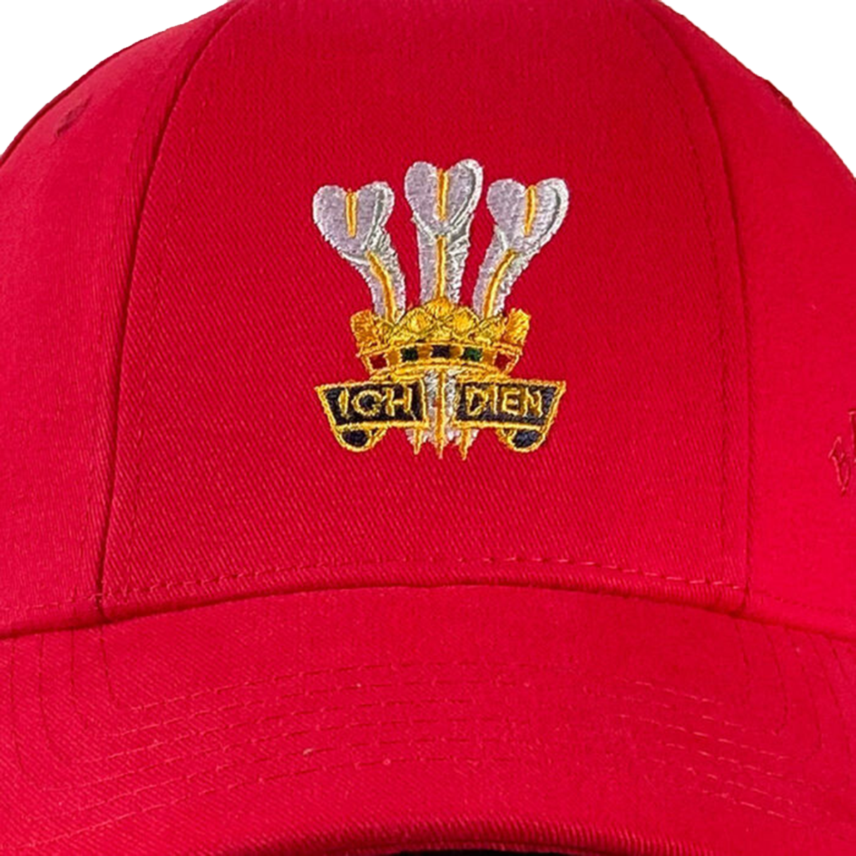 The Wales Rugby 1976 Triple Crown Cap by Ellis Rugby is a red cap adorned with an embroidered emblem celebrating the team's 1976 achievement. It features three white feathers and the words "Ich Dien" in gold, honoring Welsh rugby history.