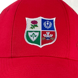 Presenting the British Rugby 1971 Lions Tour Cap by Ellis Rugby, this cap in red comes with a beautifully embroidered crest that features rose, thistle, shamrock, and dragon motifs in striking blue, white, green, and red sections. It's an ideal piece for rugby enthusiasts cherishing memories of the iconic 1971 Lions Tour.