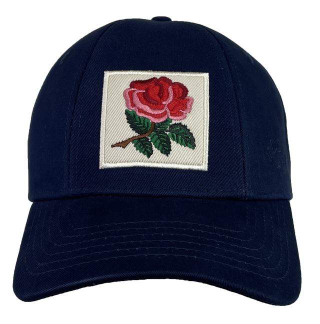 Ellis Rugby's England Rugby 1991 Six Nations Cap is a navy blue cap made from organic cotton and adorned with an embroidered patch showcasing a pink and red rose with green leaves.