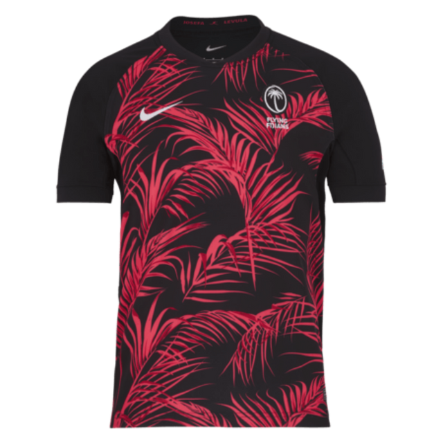 The eye-catching Fiji 24/25 Replica Away Jersey by Nike sports a vibrant black and red design accented with a palm leaf pattern, prominently displaying a logo featuring two crossed palms. Additional logos adorn the sleeves, enhancing this rugby replica jersey's dynamic and authentic appeal.