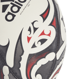 A close-up image of the All Blacks Replica Ball by adidas, showcasing black and red Maori patterns on a white background, reminiscent of an official All Blacks rugby ball.