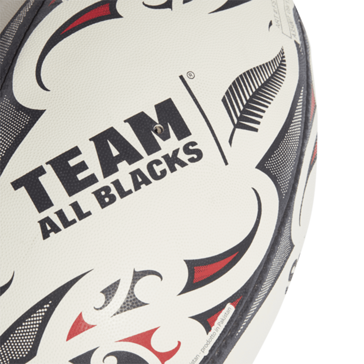 Close-up of an adidas All Blacks Replica Ball with "TEAM ALL BLACKS" written on it, featuring a white, black, and red design infused with Maori patterns.