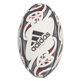 The All Blacks Replica Ball by adidas features black, red, and white Maori patterns on a plain background, creating a striking tribute to the legendary rugby team.