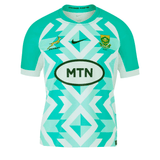 Celebrate your support with the Youth Springboks Replica SS Away Jersey by Nike, featuring a striking turquoise and white geometric pattern, the iconic MTN logo, a Nike swoosh, and the prestigious South Africa Rugby emblem on the chest.