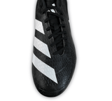 Close-up of the adidas adizero RS15 Ultimate SG 23 - Core Black/White/Carbon rugby cleat, showcasing its black design with white stripes on the side, textured surface, and black laces, specifically designed for soft ground play, set against a white background.