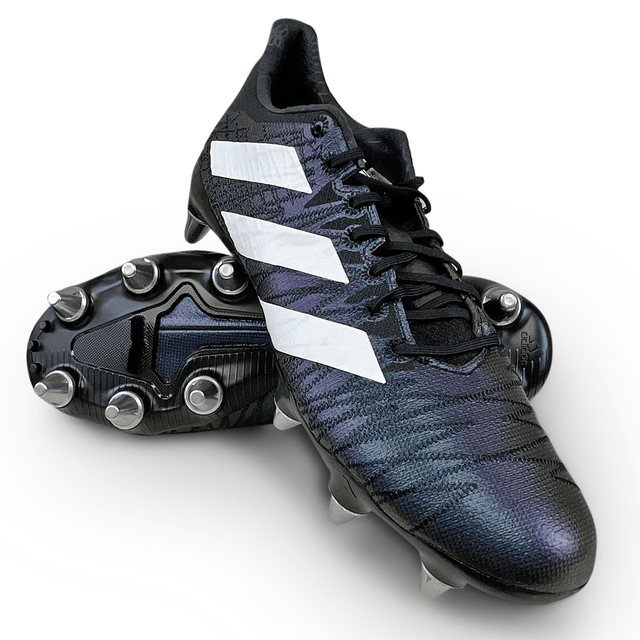 A pair of Core Black/White/Carbon adidas Kakari Z.1 SG 23 cleats with metal studs, positioned one on top of the other.