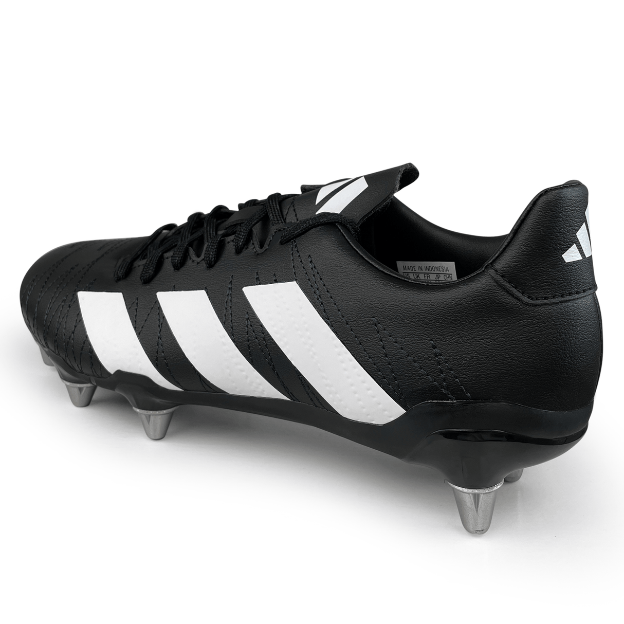 A pair of adidas Kakari SG rugby boots in Core Black, White, and Carbon with an eight-stud outsole, viewed from the back and side angle, featuring three white stripes on the side.