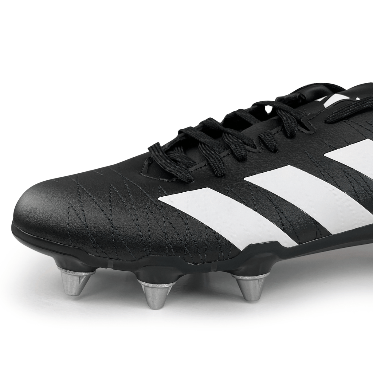 A close-up of the adidas Kakari SG rugby boots in Core Black/White/Carbon showcasing white stripes and an eight-stud outsole, designed for enhanced traction on the field.