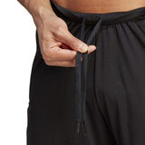 Close-up of a person’s hand adjusting the drawstrings on their black All Blacks Gym Short by adidas, featuring moisture-wicking AEROREADY technology.