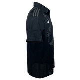 An adidas All Blacks Polo shirt in black, featuring a French Fern design on the side and diagonal stripes on the shoulder with the iconic adidas logo.