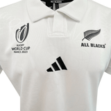 The All Blacks RWC 23 Away Supporter Jersey by adidas is a white rugby jersey featuring the Rugby World Cup France 2023 logo, the All Blacks fern emblem, and the adidas logo on the front. This jersey is perfect for fans looking to wear their pride.