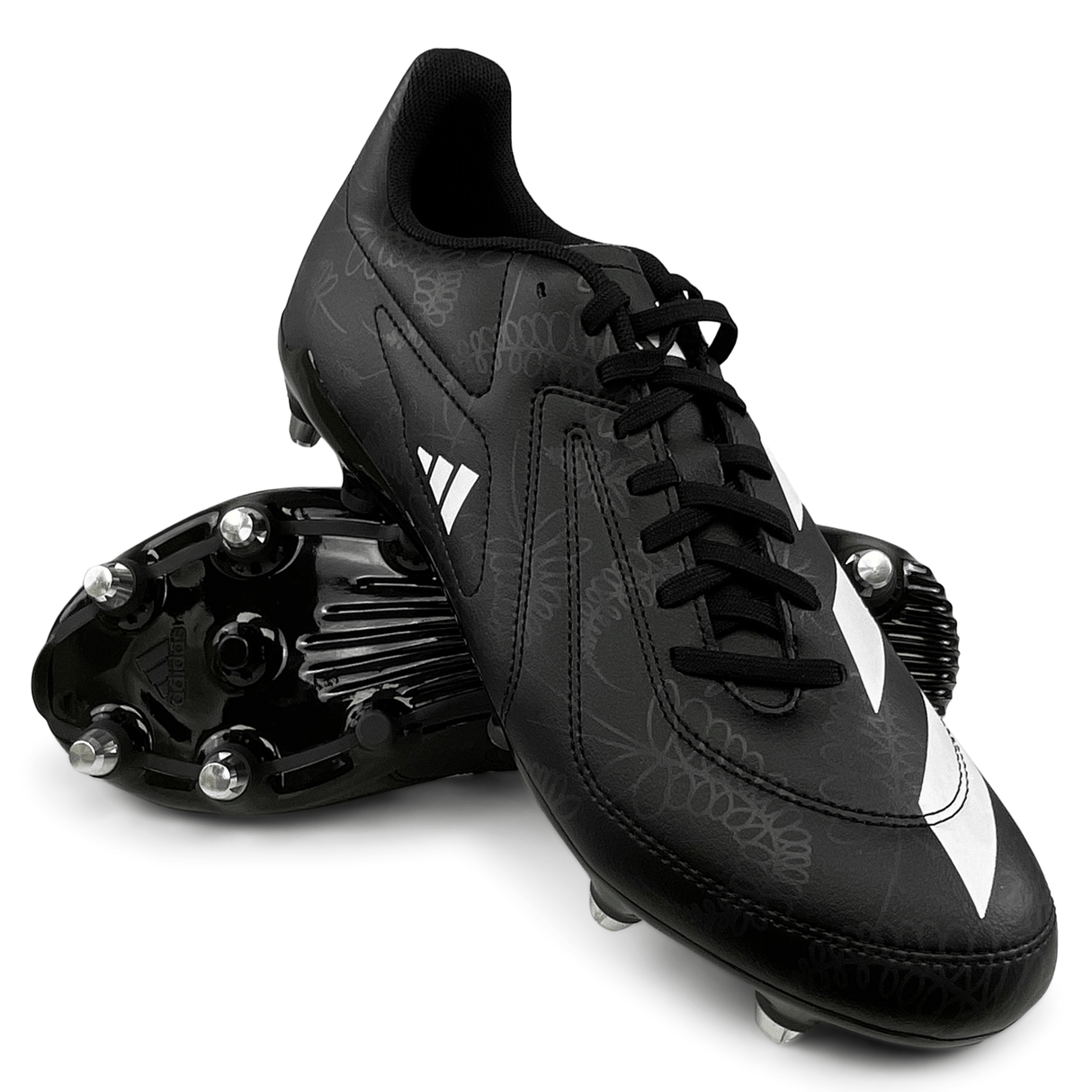 Core Black/White/Carbon soccer cleats with studded soles, reminiscent of the adidas RS15 SG 23 Soft Ground Rugby Cleat, one shoe resting on its side on top of the other.