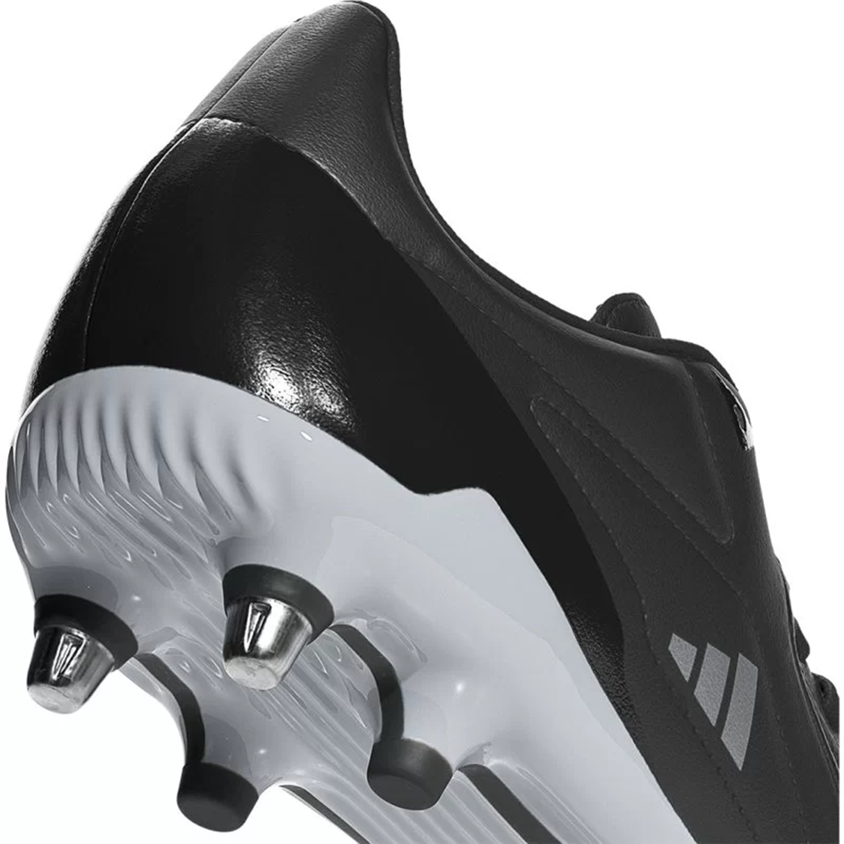 Close-up of the adidas Adizero RS15 Elite SG rugby boot in Core Black, Zero Metallic, and Silver Metallic, featuring metal studs on the sole and an adaptive leather texture, designed for optimal performance in soft ground play.