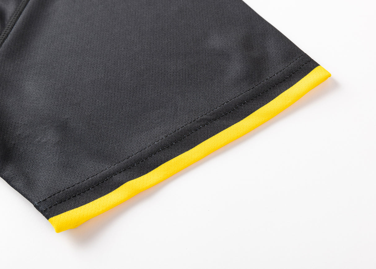 A close-up of a black fabric garment with a yellow edge on a white background evokes the classic Hurricanes Super Rugby 25/26 Team Polo by Classic Sportswear.