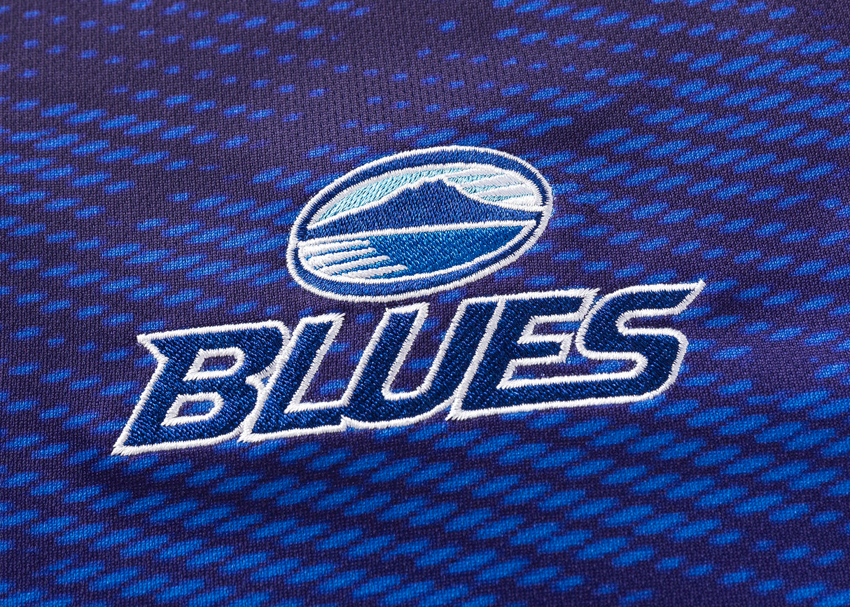 Close-up of a Blues Super Rugby 25/26 Replica Home Jersey by Classic Sportswear in blue and black, displaying "BLUES" and a circular logo with a stylized mountain.