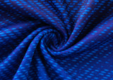 A close-up of a swirling blue fabric with a textured pattern, resembling the Blues Super Rugby 25/26 Replica Home Jersey by Classic Sportswear, highlights various shades of blue and a ripple-like design echoing the sleek style of classic sportswear.