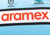 Close-up of a Sharks NRL 25/26 Replica Home Jersey by Classic Sportswear featuring the NRL Telstra Premiership and Cronulla Sutherland Sharks logos, with "aramex" in bold red across the front. Perfect for die-hard fans.